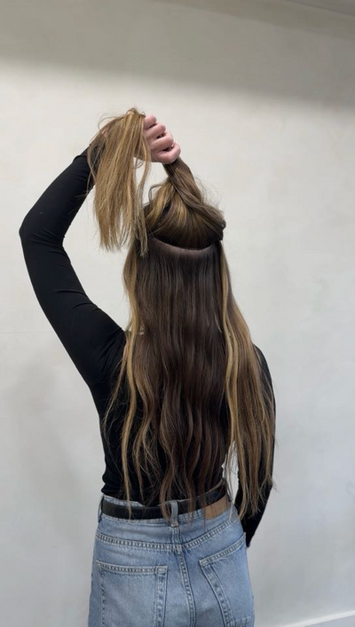 Client holding up long extension lengths to show the blend at Shade Studio in Long Branch, New Jersey